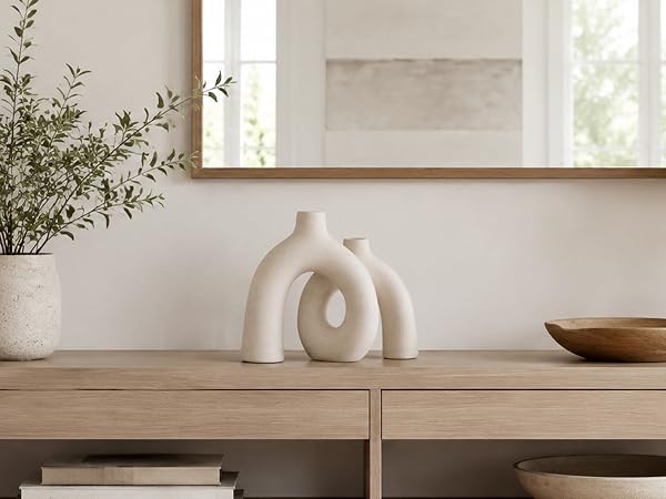 Cream ceramic donut vase displayed on a wooden console table in a neutral entryway setting