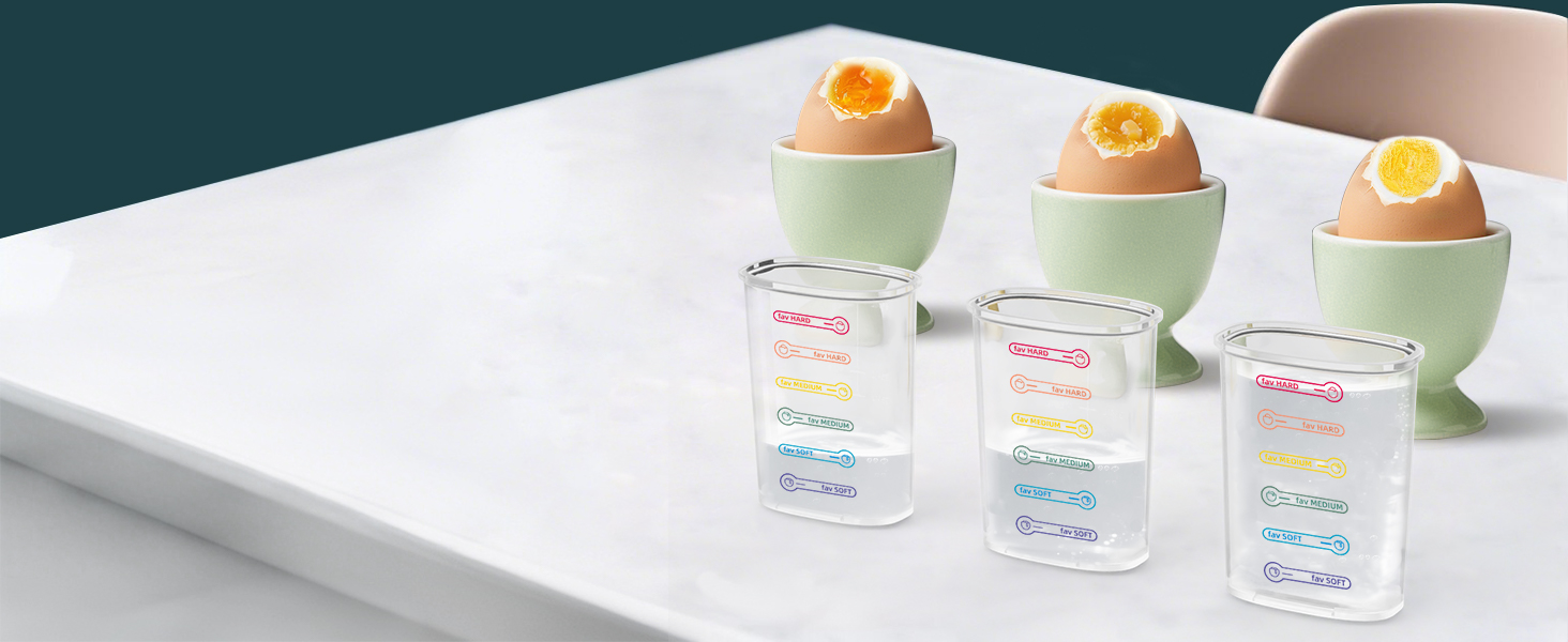Three boiled eggs in pale green egg cups alongside three clear measuring cups with colorful measurement markings, arranged on a white surface against a dark background.