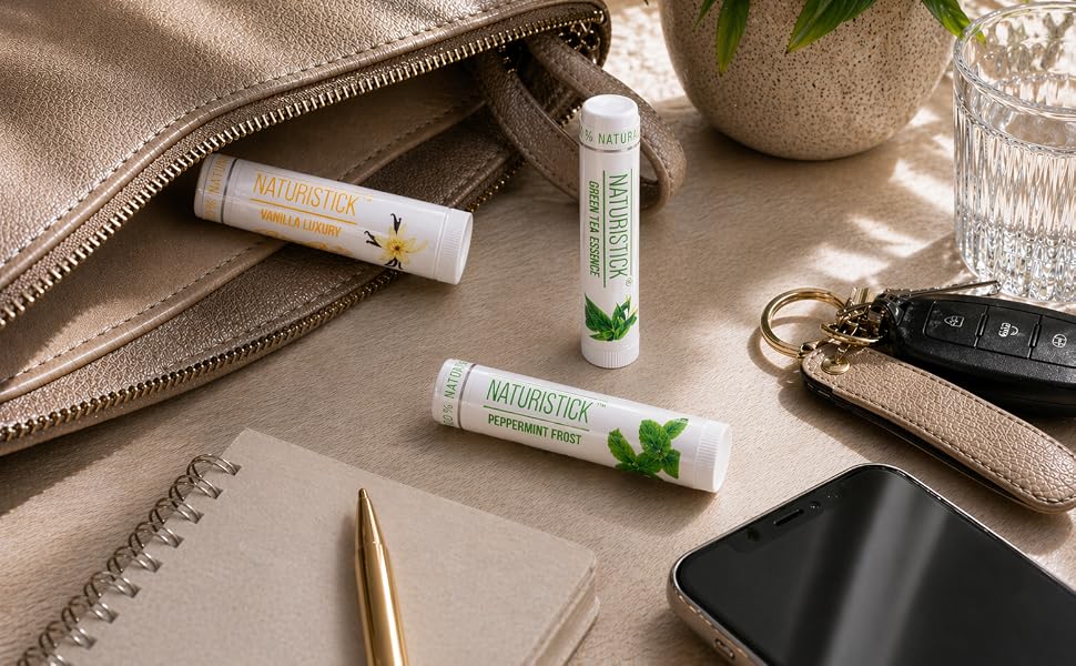Naturistick lip balms with everyday items like bag, keys, and notebook in warm natural light