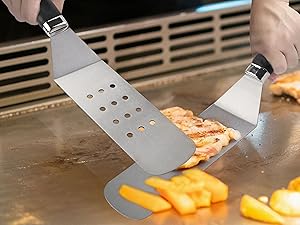 Stainless steel spatula with integrated LED lights illuminating chopped vegetables on a cooking surface.