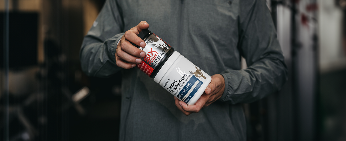 Person holding Bucked Up Creatine Monohydrate and 6 Point containers