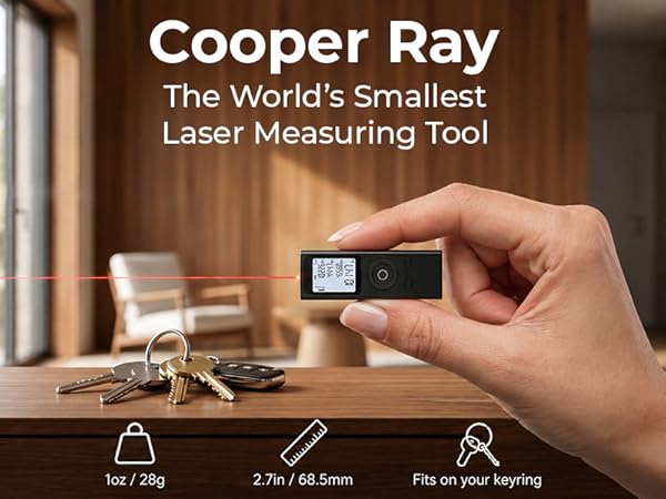 Text reads 'Cooper Ray', 'The World's Smallest', 'Laser Measuring Tool'. Hand holding compact digital laser measurement device with display screen over wooden surface with tools.
