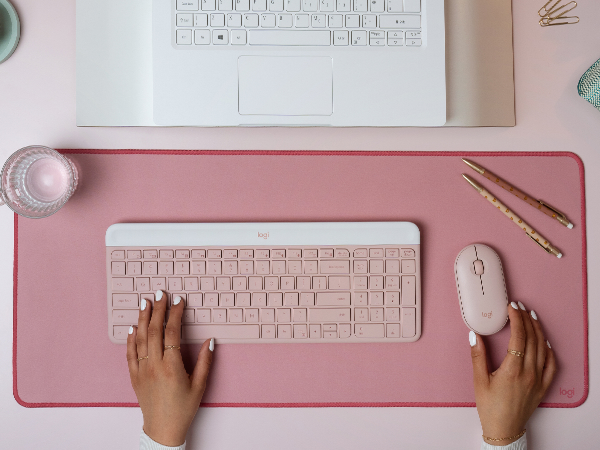 a woman using mk470 slim wireless mouse and keyboard pink combo, desk mat large mouse dark rose pad