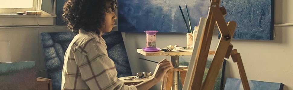 woman painting using her paint puck rinse cup