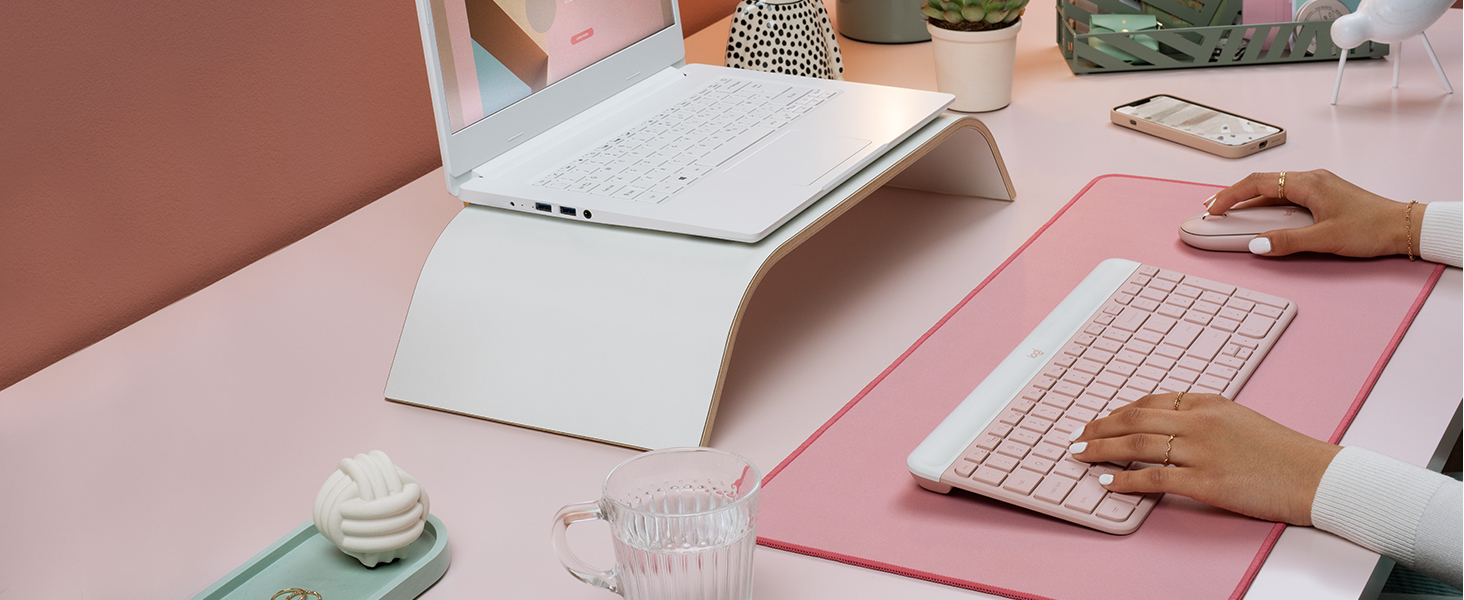 a woman using mk470 slim wireless mouse and keyboard pink combo, desk mat large mouse dark rose pad