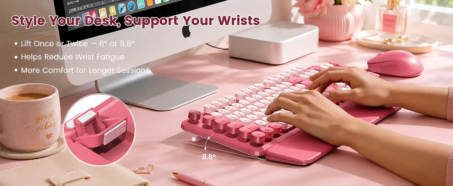 Pink round-key keyboard and matching mouse with wrist rest used on a blush desk for angled typing.