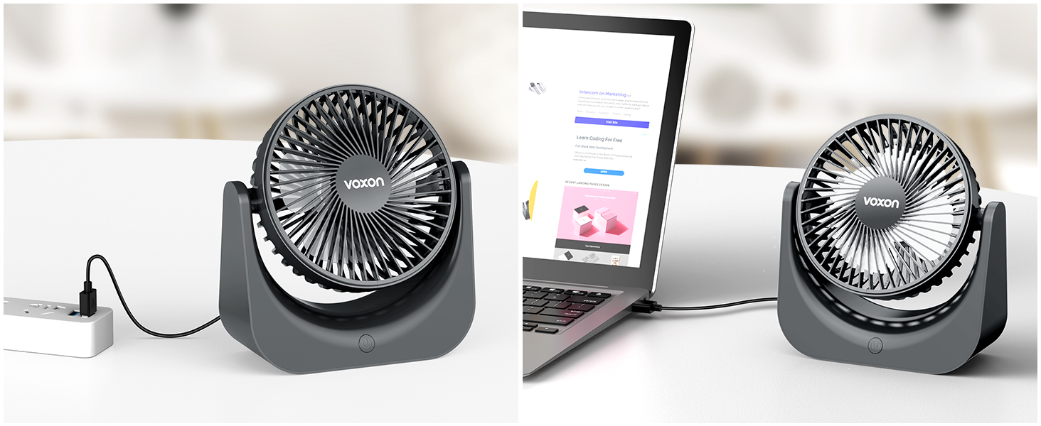 Two small black desktop fans next to a laptop displaying a colorful screen, set on a light-colored surface.