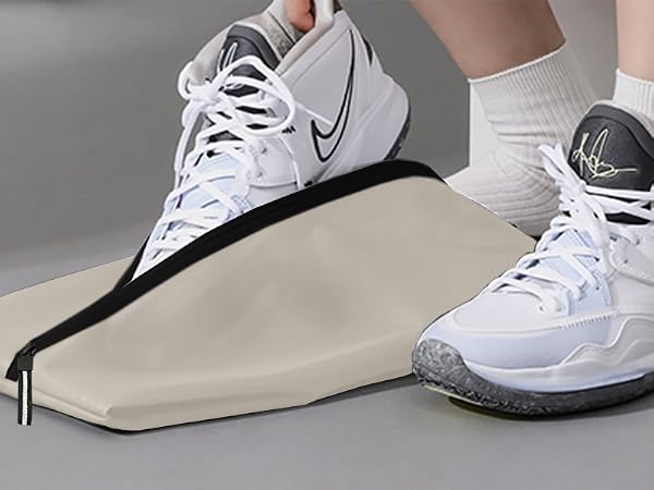 Athletic footwear positioned on a beige folding or collapsible shoe cover mechanism with black trim.