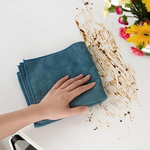 a woman's hand wiping a dirty table