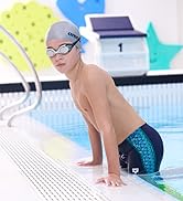 boy wearing silver arena swim cap arena swim goggles and arena swim jammers in an indoor pool