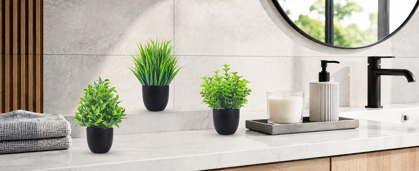 three artificial green plants black pots bathroom vanity decor