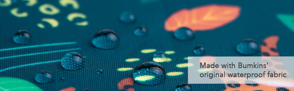 Closeup of beaded water droplets on a dark blue and multicolor print fabric