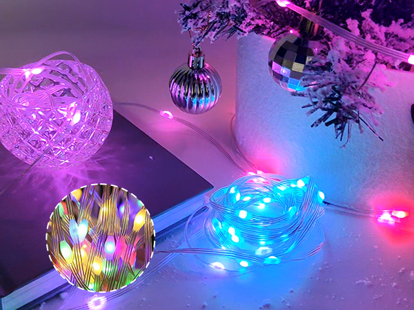 Decorative LED string lights in various colors illuminating Christmas ornaments and creating a festive atmosphere with purple, blue, and pink hues.