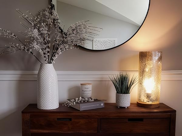 White textured ceramic vase, minimalist design, placed on wooden cabinet