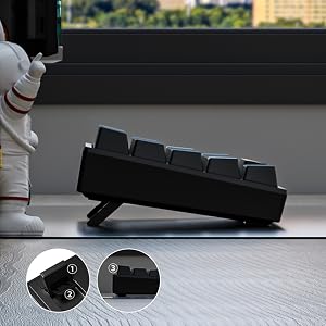 Black mechanical keyboard with person's hand and white shoe visible above. Below shows detached keyboard components including key switches and base unit.