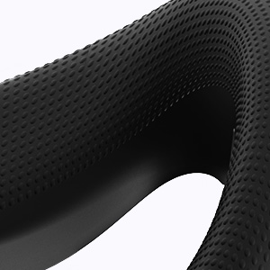 Close-up detail of a black textured surface with a dimpled or honeycomb pattern, showing depth and contours against a white background.