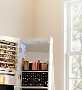 Bright minimalist interior space with white built-in shelving unit displaying cookbooks and kitchen items near window with natural light.