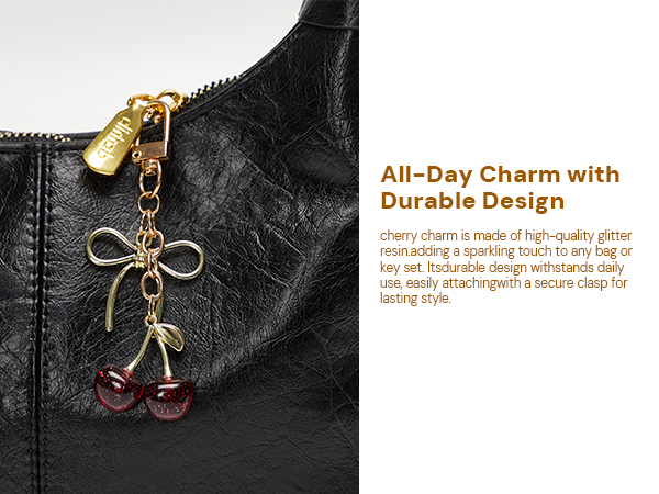 Cherry Bag Charm with Gold Bow and Clasp Attached to Black Leather Handbag