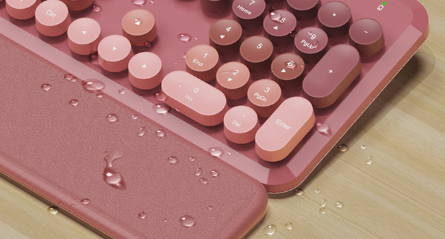 Water droplets on wireless keyboard and wrist rest showing splash resistant design easy wipe clean