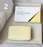 Text reads "ADVANCED SALICYLIC & SULPHUR SCRUB SOAP". Pale yellow exfoliating soap bar displayed next to white packaging box with black diagonal stripe design element.