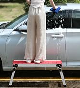 a woman standing on a platform next to a car.