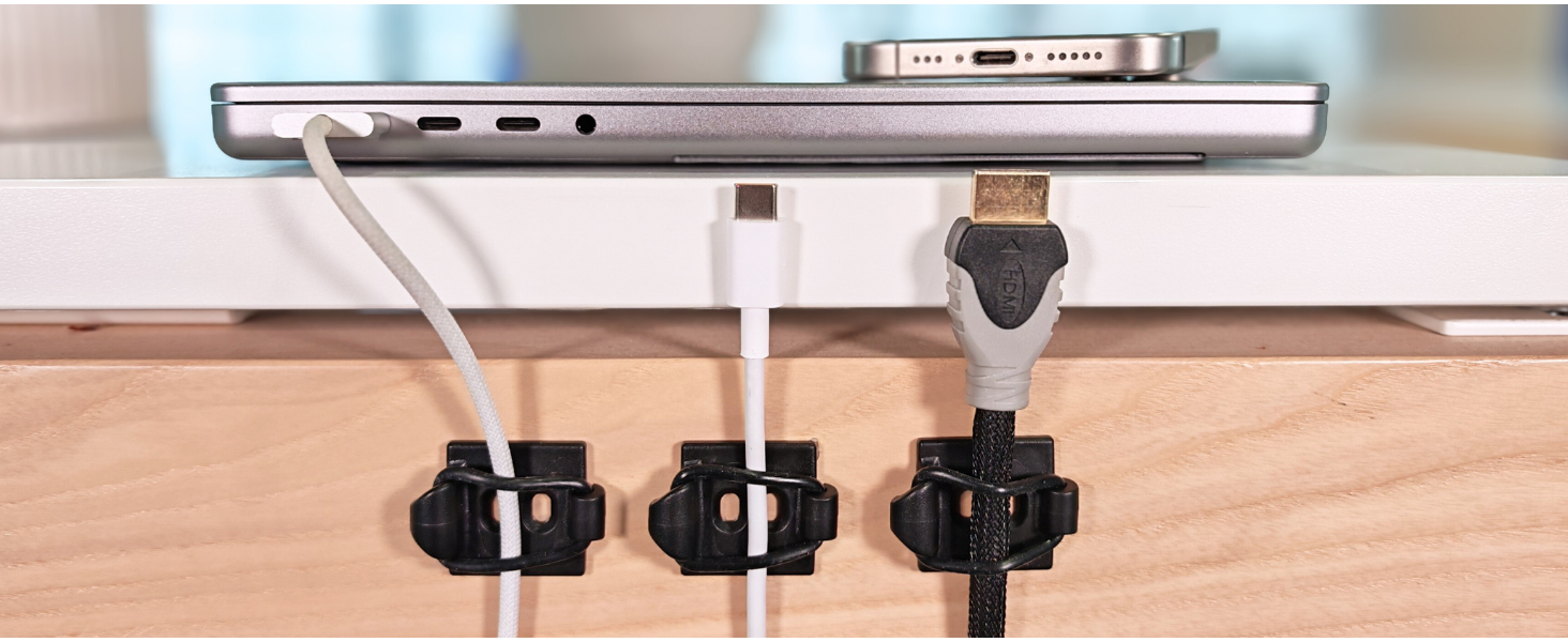 Cables secured on desk dext to laptop.