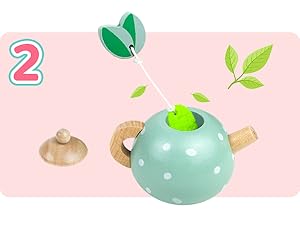 a teapot with a plant inside of it.