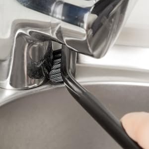 a person cleaning a sink with a brush.