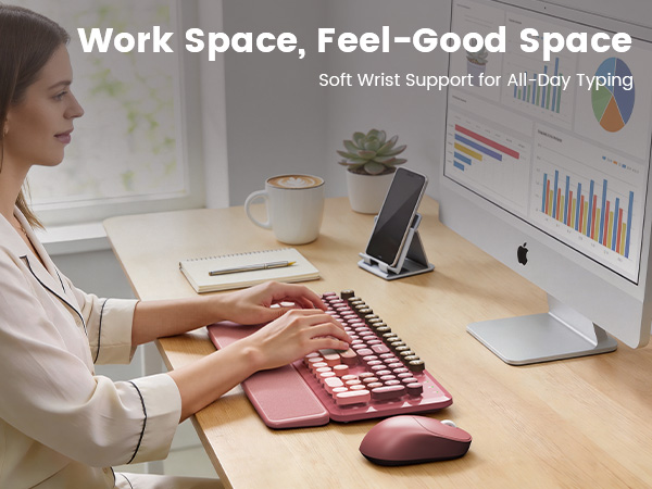 Woman typing on pink wireless keyboard mouse combo with wrist rest on tidy desk