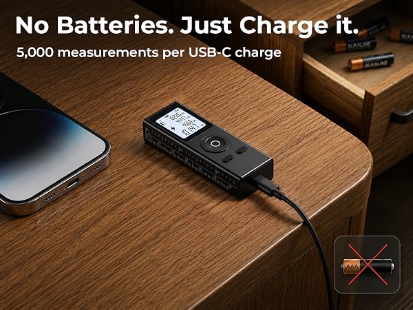Black laser measuring tool charging via USB-C cable, with disposable batteries crossed out