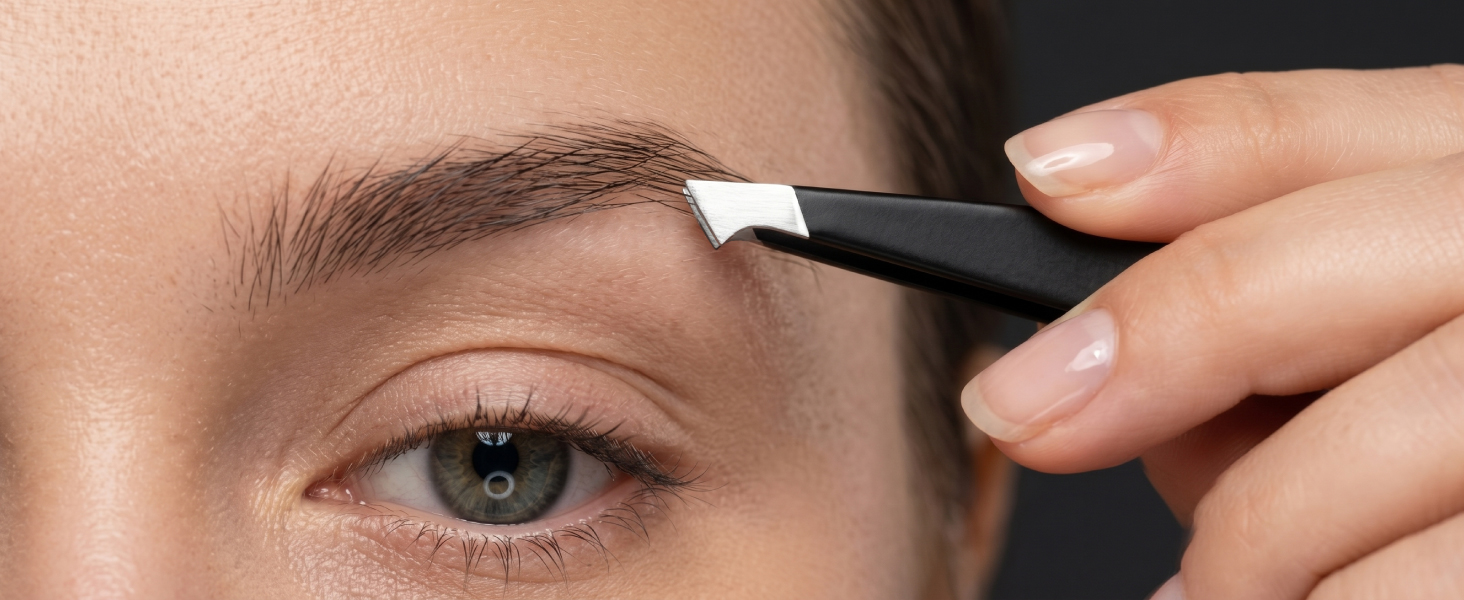 Close-up of eyebrow area showing application of dark eyebrow product with brush applicator near natural eyebrow.