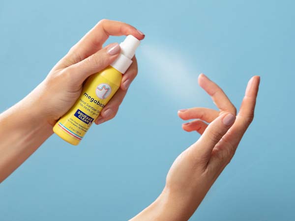 Hand sanitizer spray on blue background.