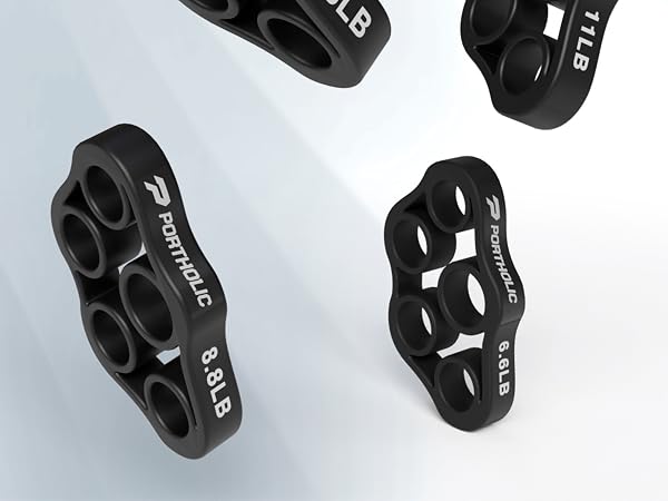 Black plastic climbing holds with multiple finger holes. Two designs shown: one with four holes, another with three. Text visible on holds indicating weight.