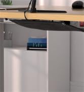 A sleek, stainless steel refrigerator with a digital display panel on the upper front. The fridge is placed in a kitchen setting with wooden countertops visible.