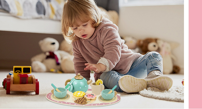 a toddler playing with a tea set