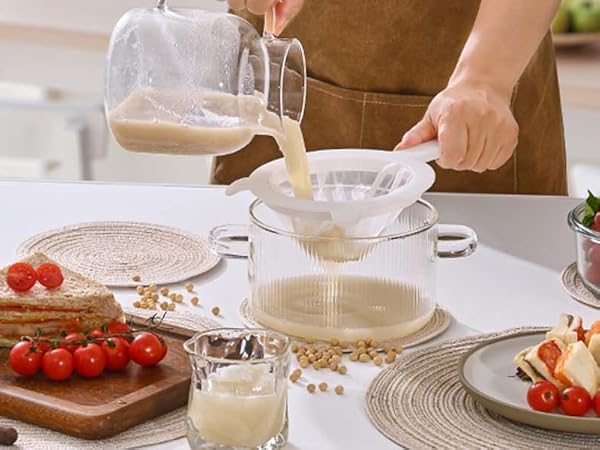 in the morning, woman brews soy milk and drinks it, sandwich and fruits for breakfast