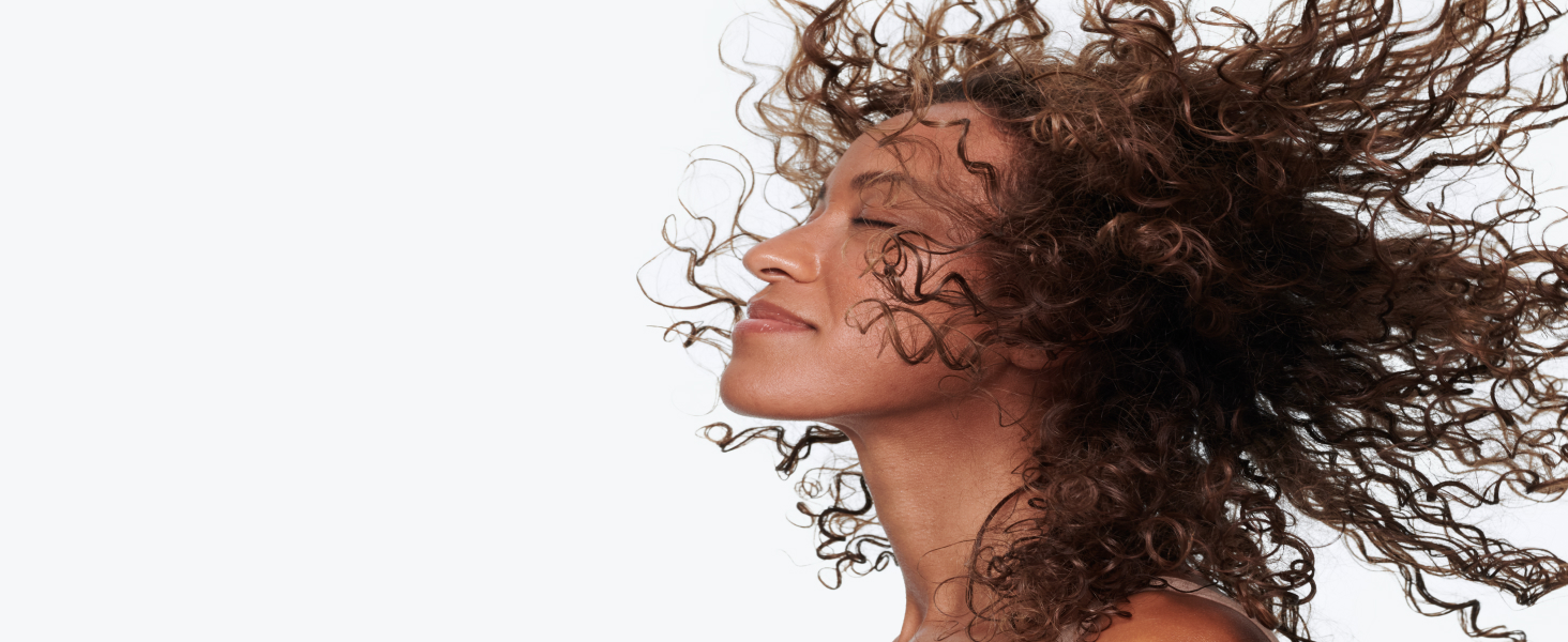 Woman's profile with curly, healthy-looking hair.