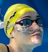 woman wearing a yellow arena swim cap and arena swim goggles under water in a pool
