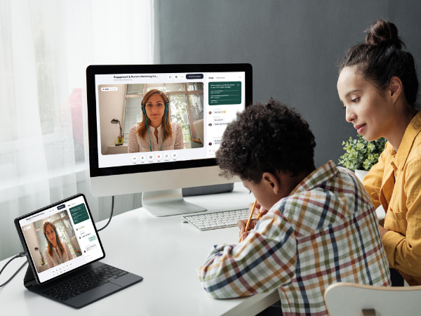 Desktop and tablet setup showing video conference meeting with multiple participants in professional setting