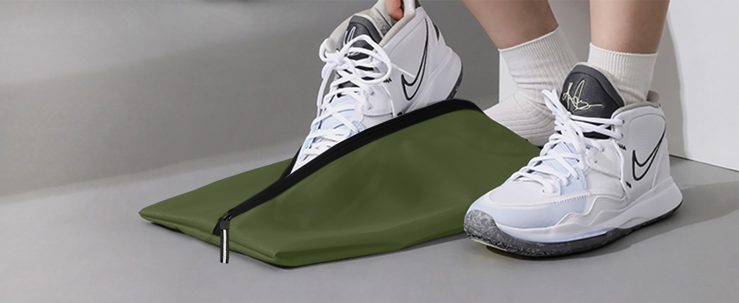 White Nike athletic shoes shown with an olive green fabric product on a light gray surface.