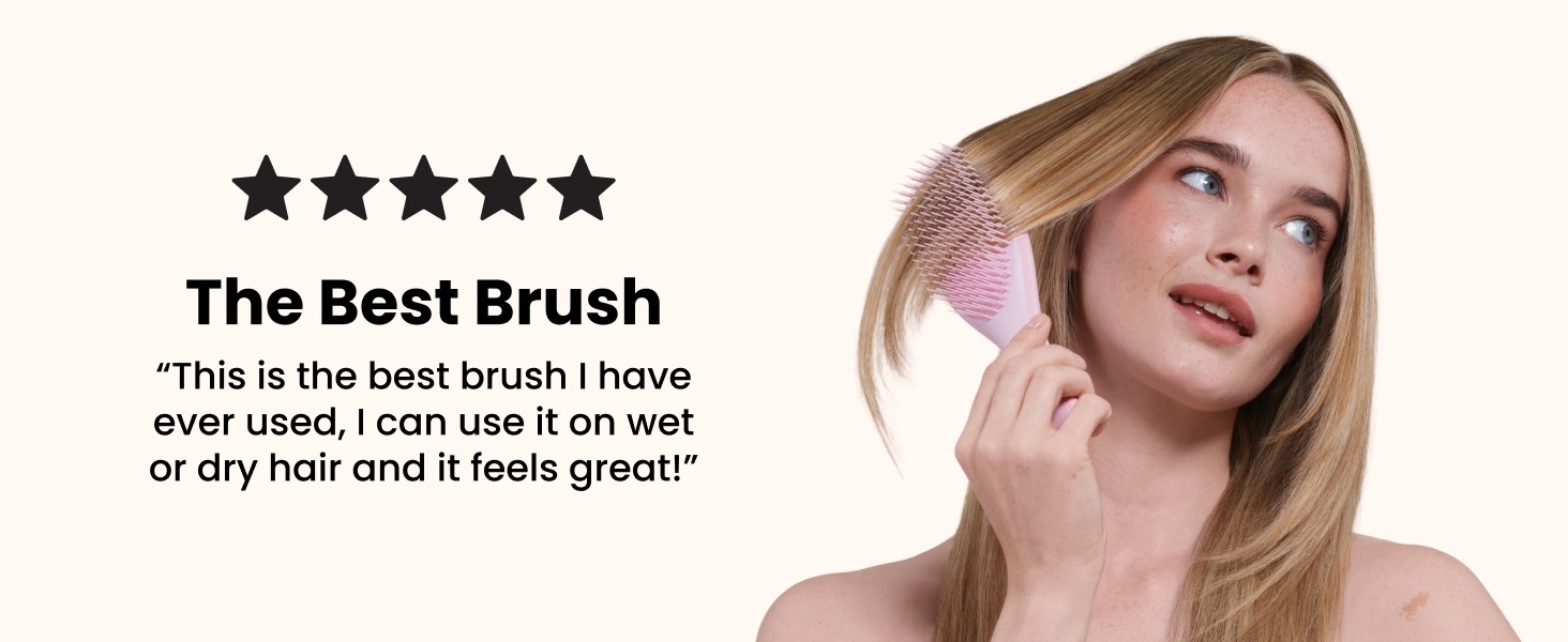 A woman brushing her hair with a pink ultimate detangler brush.