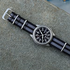 Black and Grey Striped Nylon Watch Band on Black Watch against Granite Background