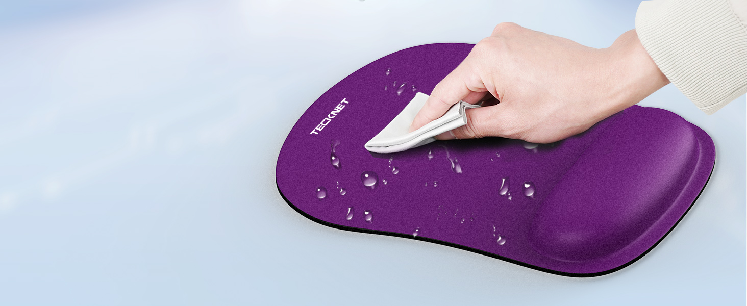 Purple ergonomic mouse pad with wrist rest. Hand demonstrating use, with water droplets visible on pad surface, indicating water-resistant properties.