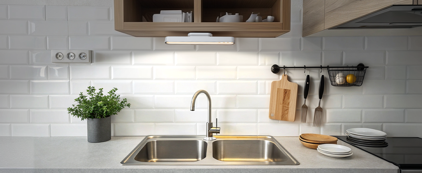 a kitchen sink with a light under the sink.