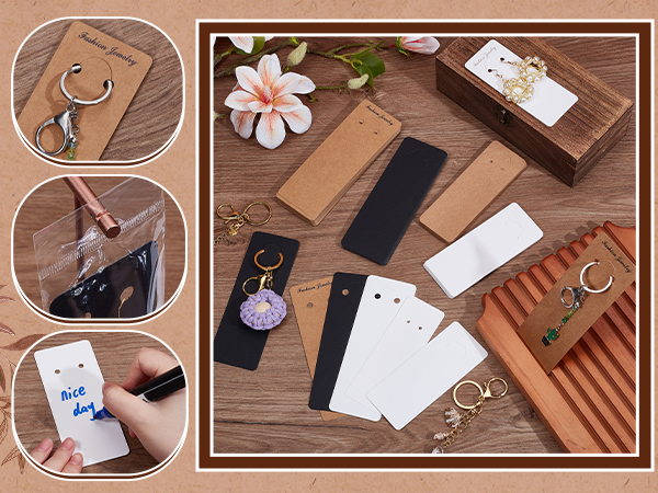 Assortment of earring display cards and packaging materials in various colors including kraft, black, and white. Includes key rings, tags, and a wooden display box on a wooden surface.