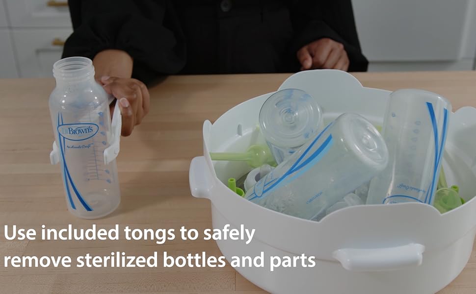 included tongs taking bottles out of steam sterilizer