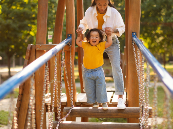 child and adult happily playing on playground