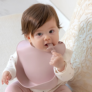 samigo baby wearing bib using spoon