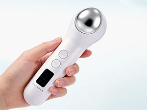 Hand holding a white facial device with metallic head.