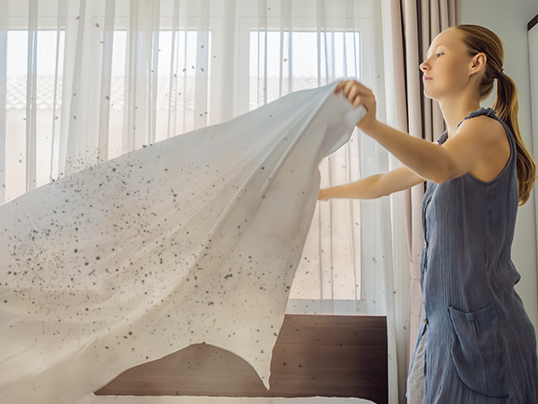 Shaking dust off a bedsheet. M05 Air purifier traps dust particles, keeping your home air cleaner